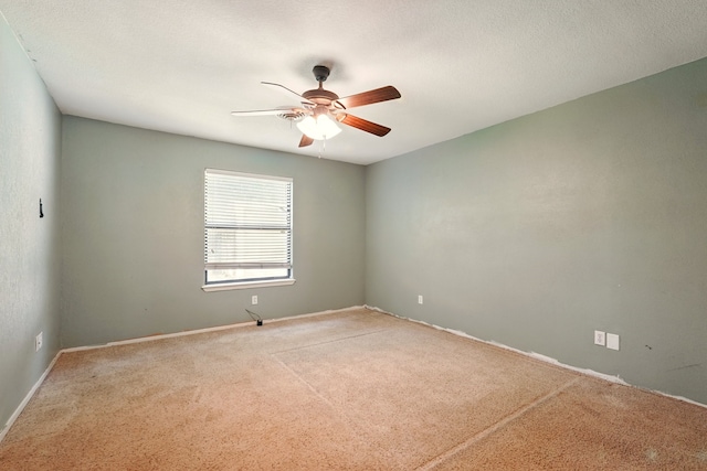 carpeted spare room with ceiling fan and baseboards