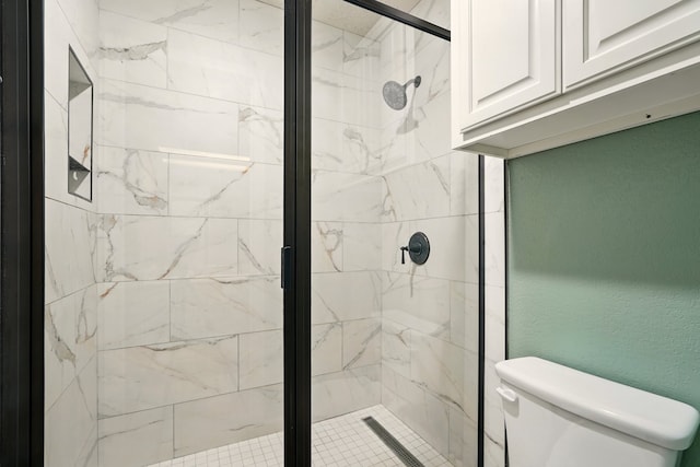bathroom featuring toilet and a shower stall