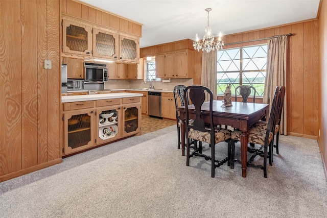 303 Luby Dr, Tom Bean, TX 75489 - dining space featuring a chandelier, light colored carpet, and wood walls