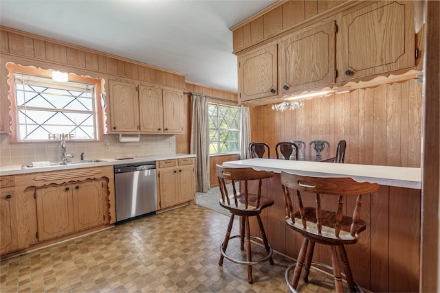 303 Luby Dr, Tom Bean, TX 75489 - kitchen featuring dishwasher, a sink, light countertops, wood walls, and a breakfast bar area