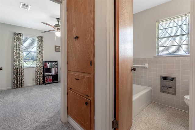 303 Luby Dr, Tom Bean, TX 75489 - full bath with toilet, a ceiling fan, a bathtub, heating unit, and tile walls