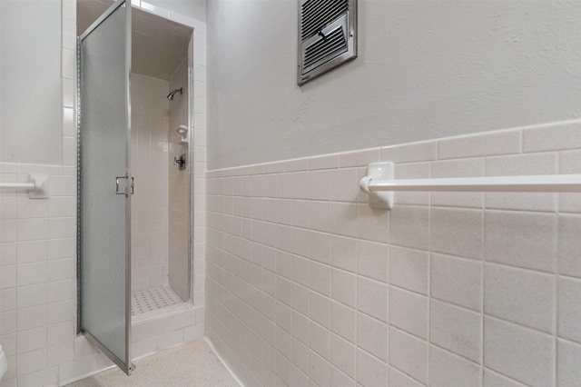 303 Luby Dr, Tom Bean, TX 75489 - full bath with tile walls, a shower stall, and a wainscoted wall