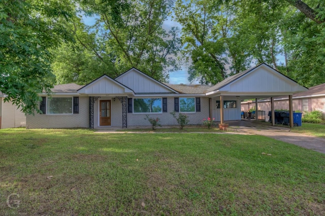 ranch-style house featuring a front yard, concrete driveway, a carport, and board and batten siding