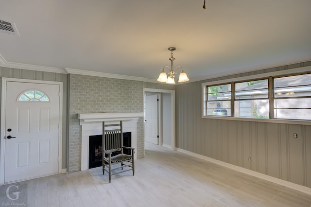 living room with plenty of natural light, crown molding, wood finished floors, and a chandelier