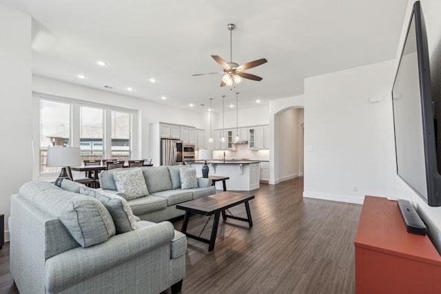 1654 Castleford Dr, Forney, TX 75126 - living room with ceiling fan, arched walkways, dark wood-style flooring, recessed lighting, and baseboards