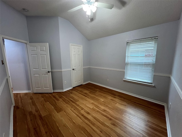 920 Joshua Dr, Burleson, TX 76028 - unfurnished bedroom featuring wood finished floors, vaulted ceiling, baseboards, ceiling fan, and a textured ceiling