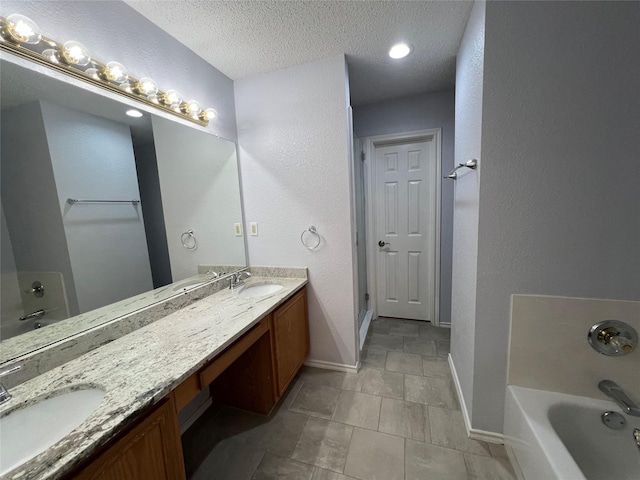 920 Joshua Dr, Burleson, TX 76028 - full bathroom featuring baseboards, a bathtub, a textured ceiling, double vanity, and a textured wall