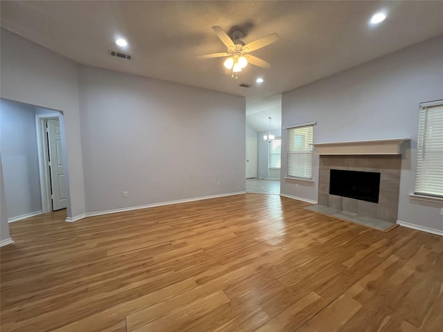 920 Joshua Dr, Burleson, TX 76028 - unfurnished living room featuring a ceiling fan, light wood-style flooring, a fireplace, baseboards, and a chandelier