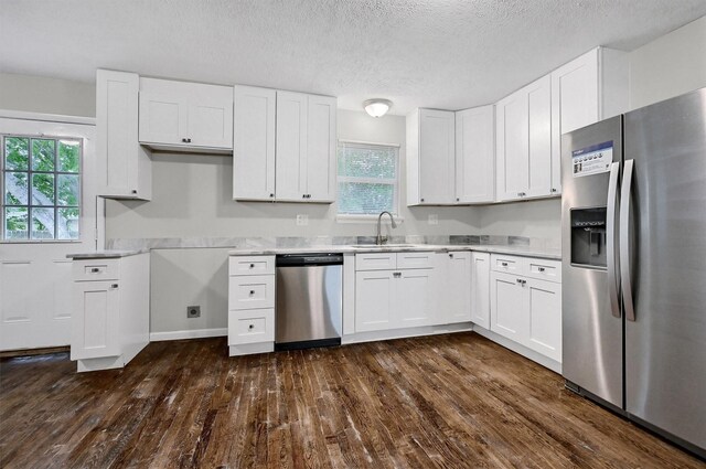 2519 N Hickory St, Sherman, TX 75092 - kitchen featuring stainless steel appliances, a sink, dark wood-style flooring, healthy amount of natural light, and a textured ceiling