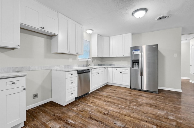 2519 N Hickory St, Sherman, TX 75092 - kitchen featuring appliances with stainless steel finishes, dark wood-style floors, a textured ceiling, and white cabinets