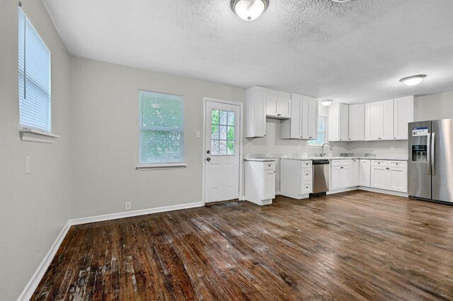 2519 N Hickory St, Sherman, TX 75092 - kitchen featuring stainless steel appliances, light countertops, baseboards, dark wood-style floors, and white cabinetry