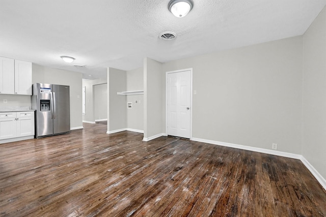 2519 N Hickory St, Sherman, TX 75092 - unfurnished living room with dark wood-style floors, baseboards, and a textured ceiling