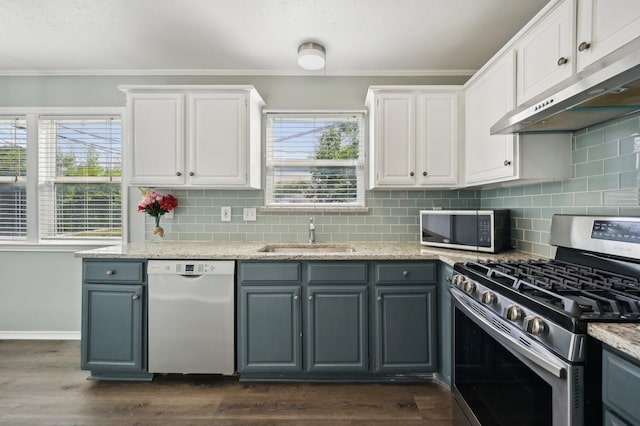 8609 N Normandale St, Fort Worth, TX 76116 - kitchen with appliances with stainless steel finishes, under cabinet range hood, crown molding, white cabinetry, and dark wood-type flooring