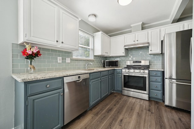 8609 N Normandale St, Fort Worth, TX 76116 - kitchen featuring stainless steel appliances, under cabinet range hood, white cabinets, dark wood-style flooring, and ornamental molding