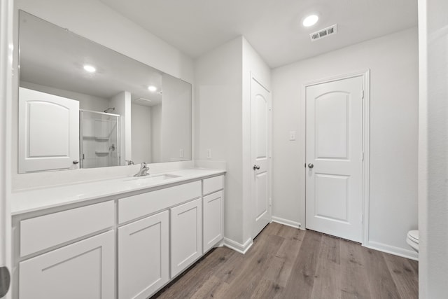 4703 Fillmore Dr, Greenville, TX 75401 - bathroom featuring wood finished floors, a stall shower, baseboards, toilet, and vanity