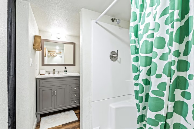 724 N Old Robinson Rd, Robinson, TX 76706 - full bathroom with wood finished floors, a textured ceiling, vanity, and shower / bathtub combination with curtain