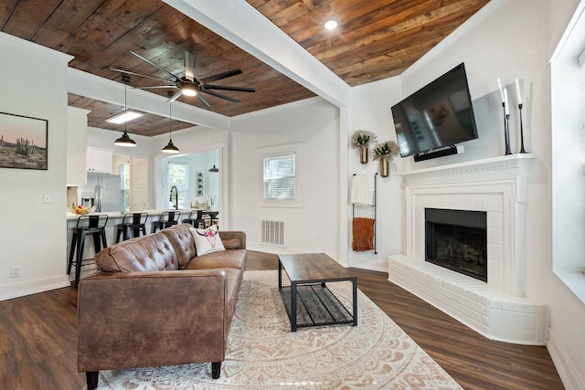 724 N Old Robinson Rd, Robinson, TX 76706 - living area featuring wooden ceiling, baseboards, a ceiling fan, dark wood-style flooring, and a fireplace with raised hearth