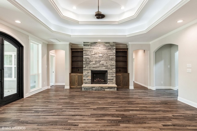 344 Whispering Oaks Trl, Sunset, TX 76270 - unfurnished living room featuring arched walkways, a raised ceiling, dark wood finished floors, ornamental molding, and baseboards