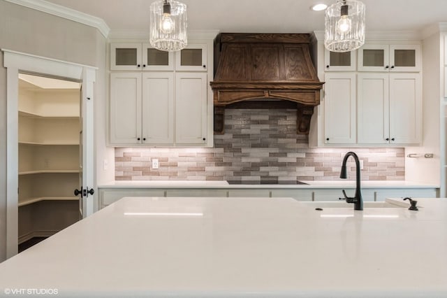 344 Whispering Oaks Trl, Sunset, TX 76270 - kitchen with a chandelier, black electric stovetop, premium range hood, pendant lighting, and light countertops
