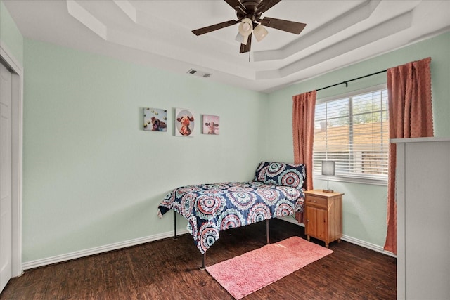 3507 Jasmine Ln, Rowlett, TX 75089 - bedroom with a tray ceiling, dark wood-style flooring, baseboards, and ceiling fan