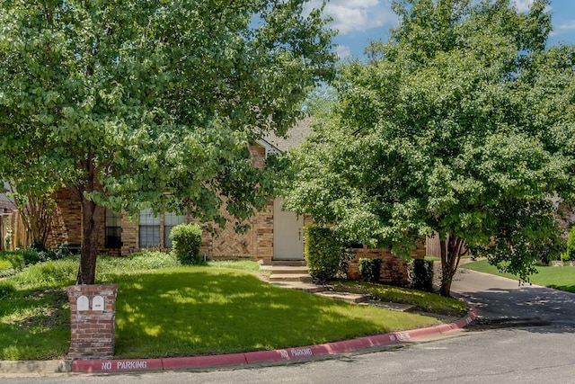 626 Lochngreen Trl, Arlington, TX 76012 - obstructed view of property featuring brick siding and a front yard