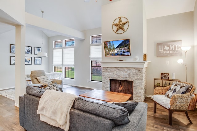 626 Lochngreen Trl, Arlington, TX 76012 - living room with high vaulted ceiling, a stone fireplace, wood finished floors, baseboards, and a ceiling fan