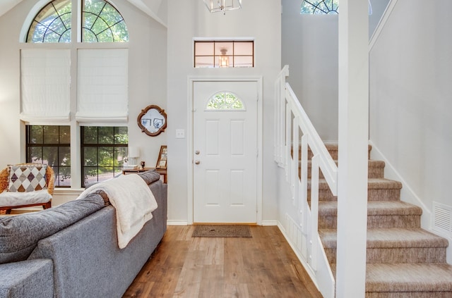 626 Lochngreen Trl, Arlington, TX 76012 - foyer with wood finished floors, a high ceiling, stairs, a chandelier, and baseboards