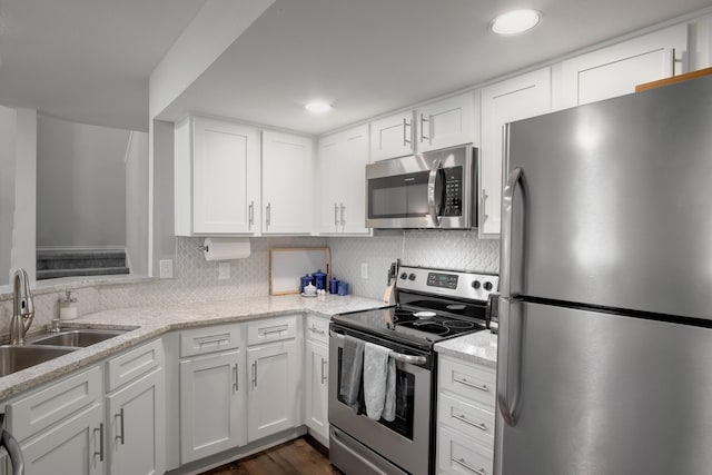 626 Lochngreen Trl, Arlington, TX 76012 - kitchen featuring appliances with stainless steel finishes, a sink, white cabinetry, backsplash, and light stone countertops