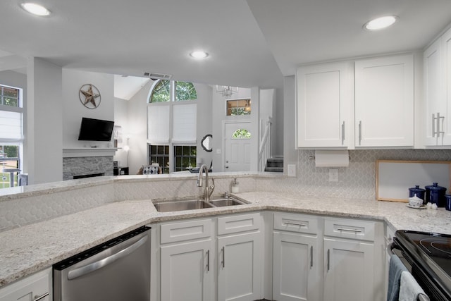 626 Lochngreen Trl, Arlington, TX 76012 - kitchen with dishwasher, a sink, a stone fireplace, white cabinetry, and decorative backsplash