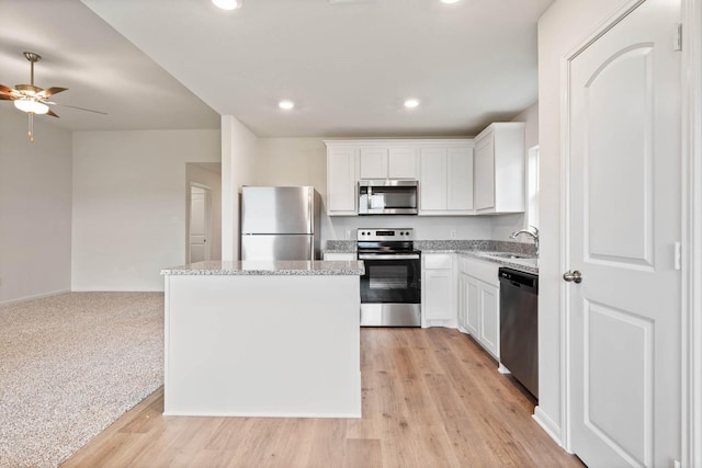 4809 Fillmore Dr, Greenville, TX 75401 - kitchen featuring appliances with stainless steel finishes, a sink, ceiling fan, a center island, and white cabinets