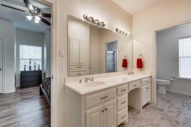 566 Glenn Ln, Red Oak, TX 75154 - ensuite bathroom with a ceiling fan, double vanity, toilet, baseboards, and a shower with door