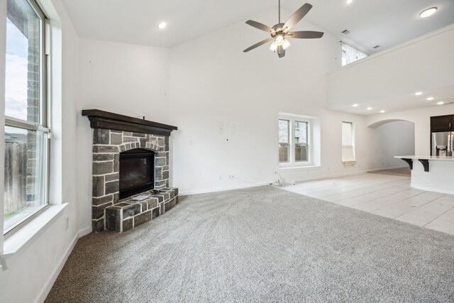 3903 Rochelle Ln, Forney, TX 75126 - unfurnished living room featuring light carpet, a ceiling fan, a fireplace, arched walkways, and baseboards