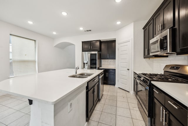 3903 Rochelle Ln, Forney, TX 75126 - kitchen with appliances with stainless steel finishes, a sink, backsplash, arched walkways, and light countertops