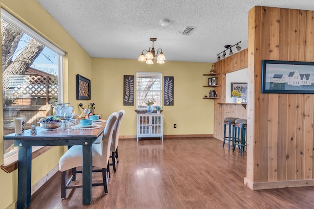 836 Silver Creek Rd, Azle, TX 76020 - dining space with track lighting, wood finished floors, a chandelier, a textured ceiling, and baseboards