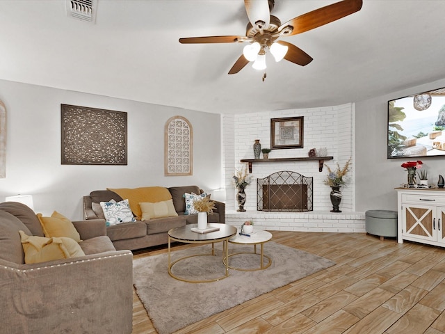 5601 Briarcrest Dr, Garland, TX 75043 - living room featuring ceiling fan, wood finished floors, and a brick fireplace