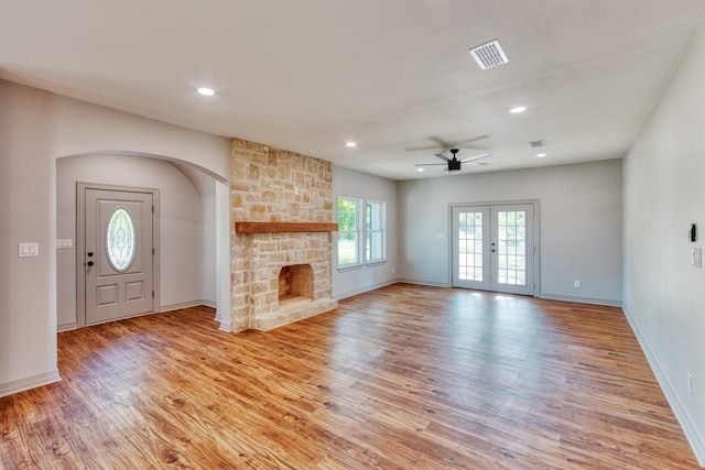 808 N Main St, Tioga, TX 76233 - unfurnished living room with light wood-style flooring, ceiling fan, a stone fireplace, baseboards, and recessed lighting