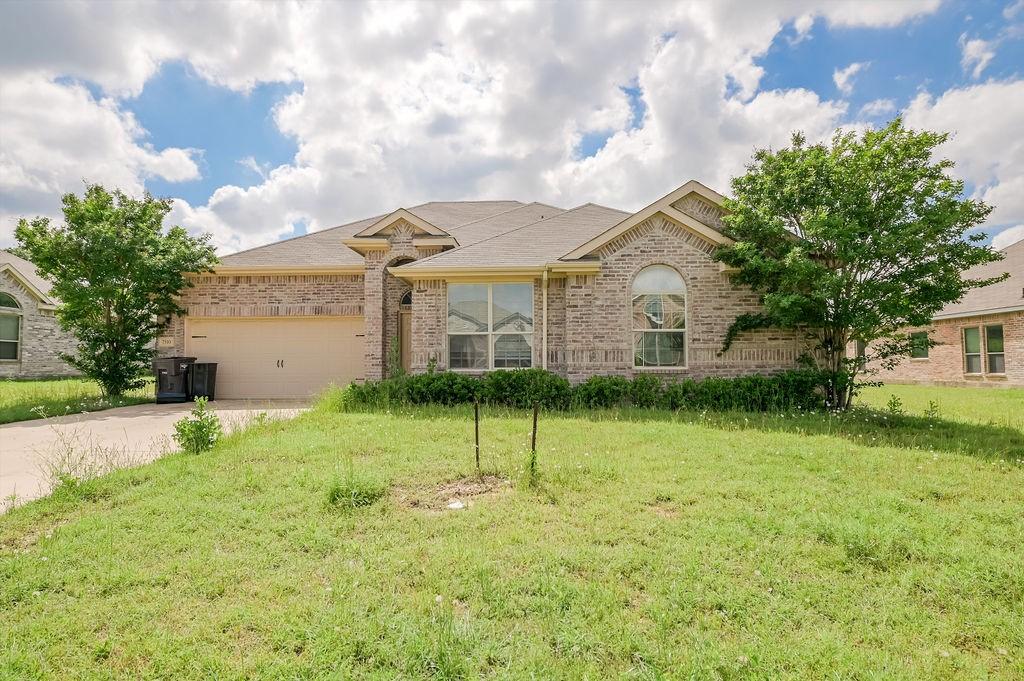 7510 Park Ave, Forest Hill, TX 76140 - view of front facade with brick siding, driveway, an attached garage, and a front yard