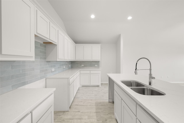 9332 Bali Dr, Fort Worth, TX 76123 - kitchen featuring a sink, tasteful backsplash, light countertops, light wood-style floors, and white cabinetry