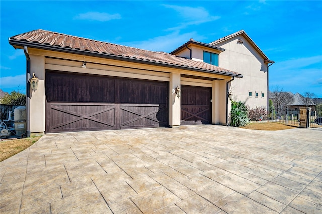 garage featuring concrete driveway and fence