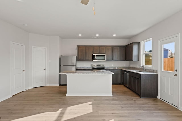 4702 Fillmore Dr, Greenville, TX 75401 - kitchen with stainless steel appliances, a center island, a sink, recessed lighting, and dark brown cabinetry