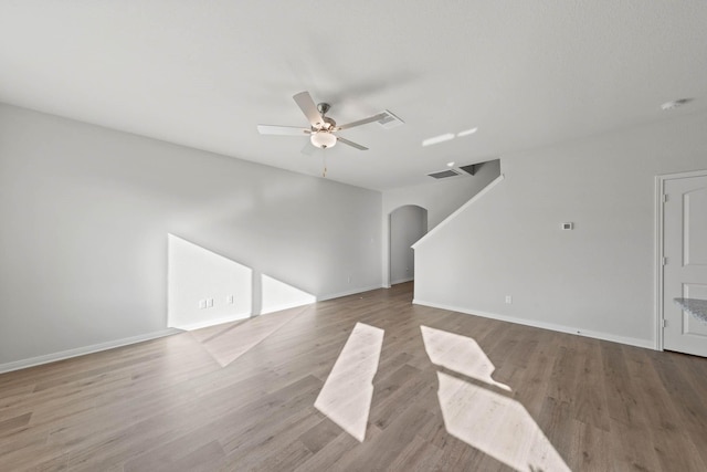 4702 Fillmore Dr, Greenville, TX 75401 - unfurnished living room featuring arched walkways, ceiling fan, wood finished floors, and baseboards