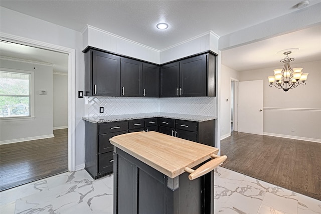 315 Westway Dr, Rockwall, TX 75087 - kitchen with light marble finish floors, a chandelier, backsplash, and crown molding