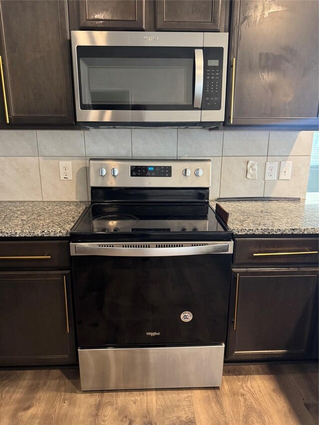 2419 Karnack Dr, Forney, TX 75126 - kitchen featuring appliances with stainless steel finishes, tasteful backsplash, dark brown cabinetry, and light stone countertops