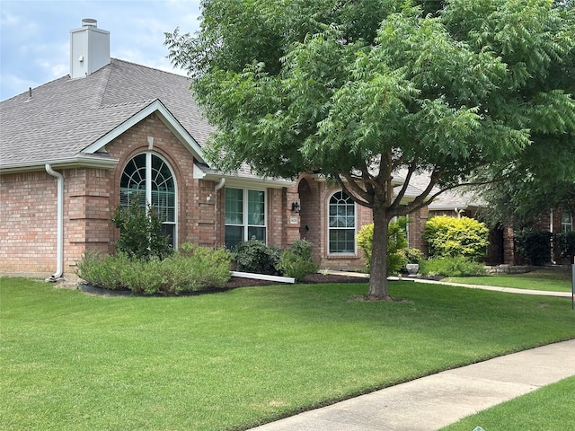 1409 Kingsley Dr, Allen, TX 75013 - view of front of house featuring brick siding, roof with shingles, a front yard, and a chimney