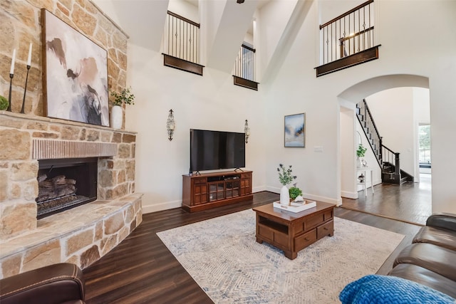 782 Sagewood Dr, Frisco, TX 75036 - living area with arched walkways, dark wood-type flooring, baseboards, a towering ceiling, and stairs