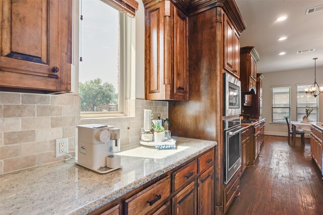 782 Sagewood Dr, Frisco, TX 75036 - kitchen with appliances with stainless steel finishes, dark wood-type flooring, light stone counters, tasteful backsplash, and decorative light fixtures