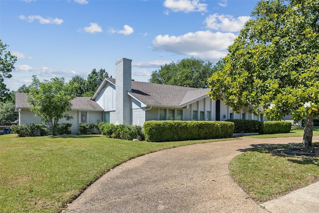 6908 Heatherknoll Dr, Dallas, TX 75248 - view of front facade with a chimney, a front yard, a shingled roof, and brick siding