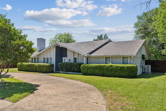6908 Heatherknoll Dr, Dallas, TX 75248 - view of front of house with central AC unit, a chimney, brick siding, roof with shingles, and curved driveway