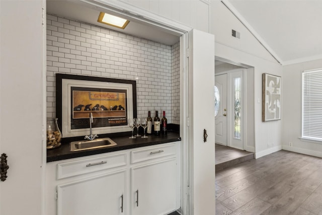 6908 Heatherknoll Dr, Dallas, TX 75248 - indoor wet bar featuring wood finished floors, lofted ceiling, and baseboards