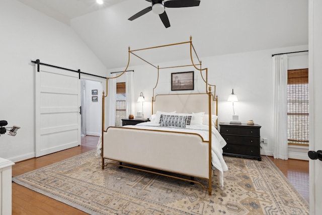 2512 Green Meadow Dr, Sachse, TX 75048 - bedroom featuring a barn door, wood finished floors, and high vaulted ceiling